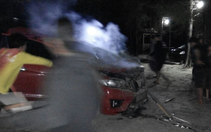 Saat kejadian, beberapa orang membantu memadamkan api yang keluar dari kap depan mobil