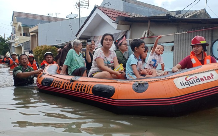 Serda Agus Babinsa Koramil 01/Kranji Evakuasi warga Banjir di Kelurahan Pejuang.