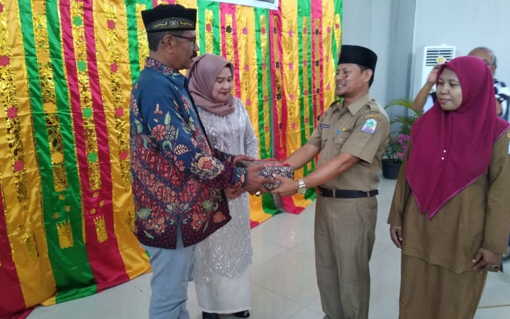 Kadisdikbud Aceh Singkil Khalilullah (kanan) saat menyerahkan cinderamata kepada Kadisdikbud lama H.Yusfit Helmi didampingi ibu.