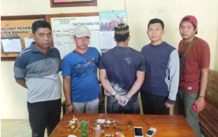 Tersangka (Tengah Diborgol) saat diamankan berikut barang bukti