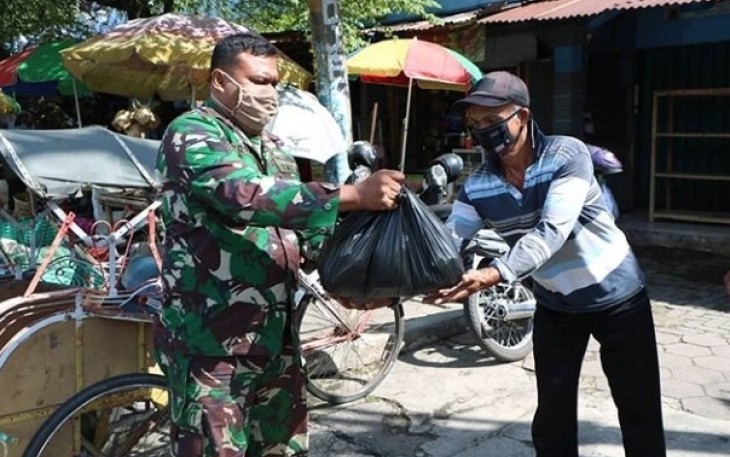 Anggota Lanud Adi Soemarmo sedang bagikan paket bingkisan sembako gratis kepada warga sekitar.