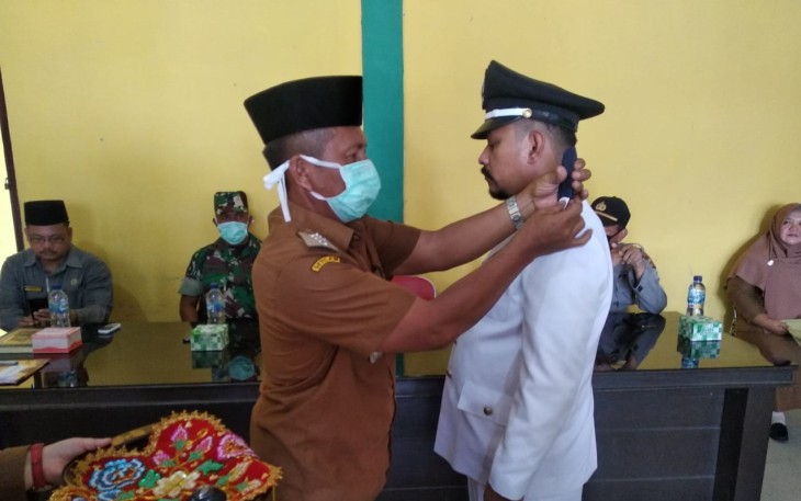 Camat Singkil Syafrizal SH menyematkan tanda jabatan Pj Kepala Kampung Rantau Gedang Singkil Kabupaten Aceh Singkil Irwansyah Rizal.