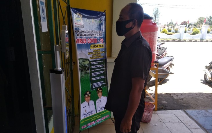 Salah seorang petugas Disdikbud Aceh Singkil saat melakukan mengukur suhu tubuh dialat pengukur didepan Kantor Dinas terkait.