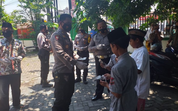 Anggota Polsek Cepiring membagikan masker kepada Jamaah di halaman Masjid Baitussalam Cepiring. Jum'at, 13/11/2020.