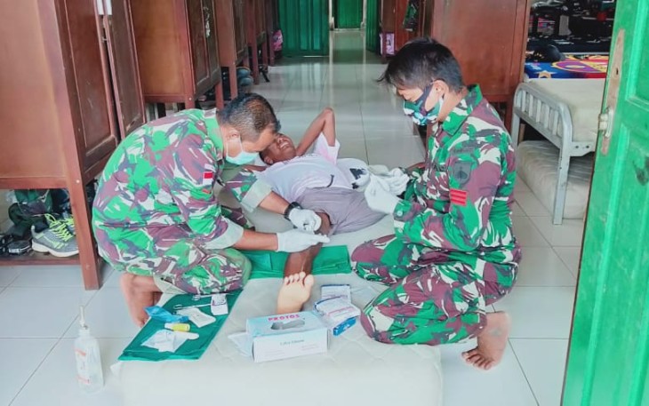 Personel Satgas Pamtas Yonif 407/PK Pos Koki Sei Beruang yang membantu mengobati Masyarakat Dusun Sei Beruang, Desa Sei Tekam, Kecamatan Sekayam, Kabupaten Sanggau, Kalimantan Barat. yang terluka akibat jatuh. Kamis (11/03/2021).