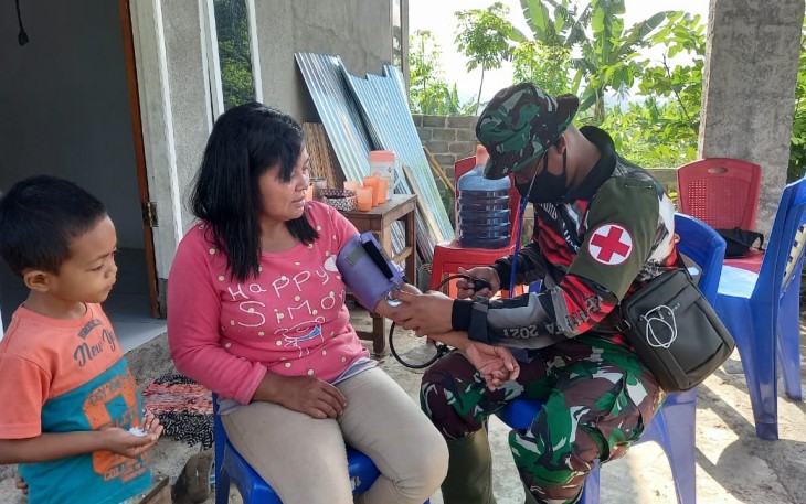 Tim kesehatan satgas TMMD kodim Bitung saat melakukan tensi darah kepada warga
