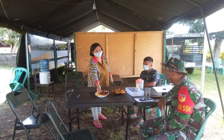 Warga menyuguhkan ubi goreng kepada anggota satgas yang berada di Posko
