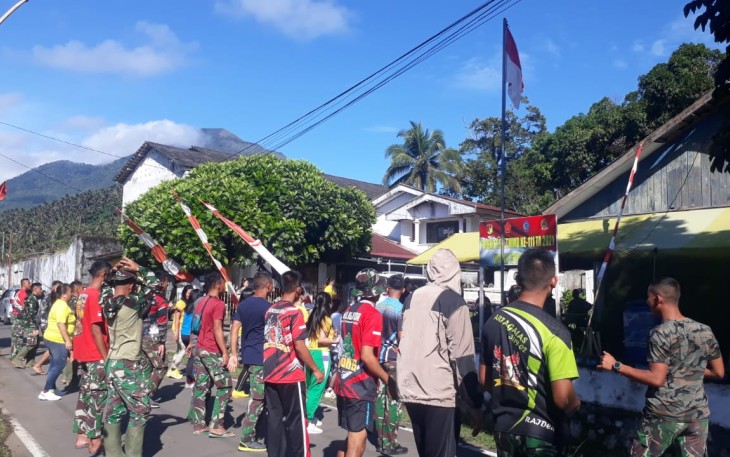 Personil satgas TMMD bersama warga sekitar saat berjemur di pagi hari