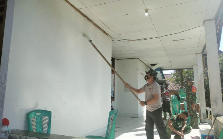 Personil satgas TMMD saat melakukan pengecetan kantor kelurahan komersot