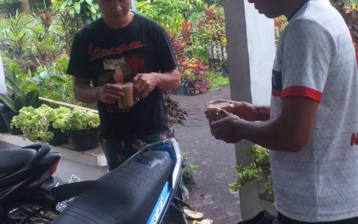 Personil satgas TMMD ke-111 kodim 1310/Bitung saat komsos bersama warga sambil menikmati segelas kopi susu
