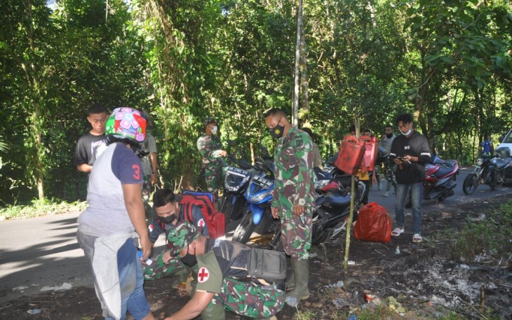 Personil satgas TMMD kodim Bitung saat memberikan pertolongan kepada warga yang mengalami kecelakaan