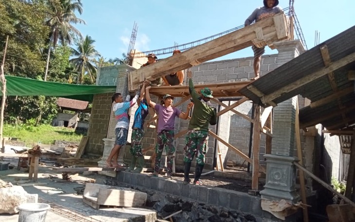 Personil satgas TMMD kodim Bitung saat bantu warga dirikan tiang teras rumah