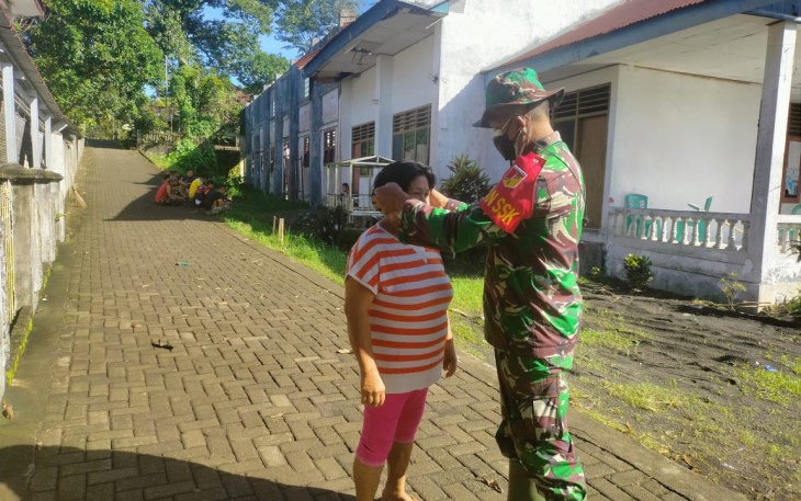 Dan SSK TMMD Lettu INF Jullen Tonny Kasiaheng saat berbagai masker dan memasangkan masker kepada salah satu warga yang melintas dan tak gunakan masker