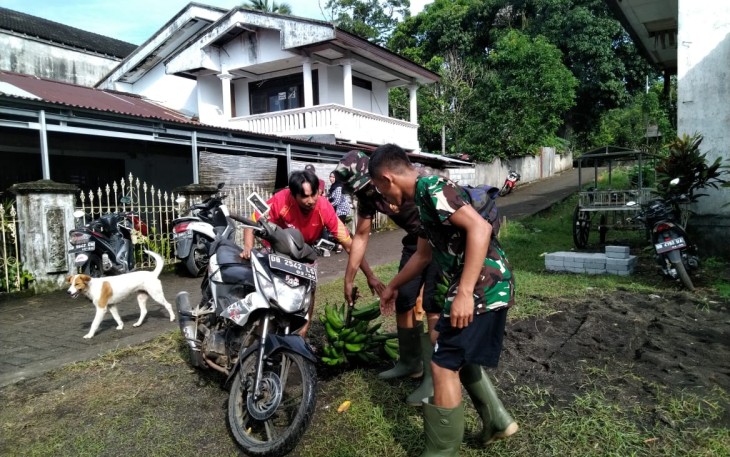 Warga saat mengantar tiga tandang pisang ke posko TMMD