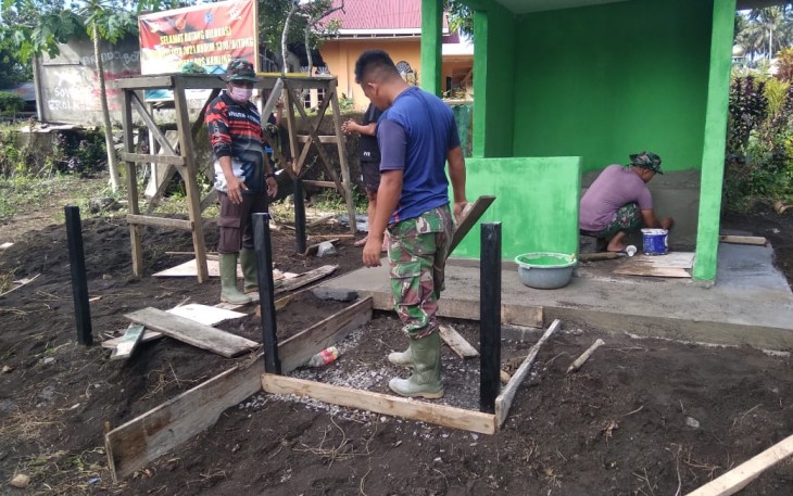 Satgas TMMD kodim Bitung saat memasang tiang pagar Poskamling