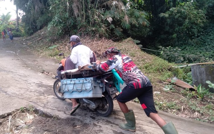 Personil satgas TMMD kodim Bitung saat bantu warga Dorong motor