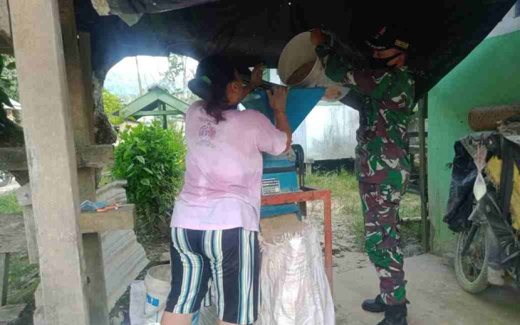 Anggota Satgas Yonif 144/JY Bantu Menggiling Padi Warga 