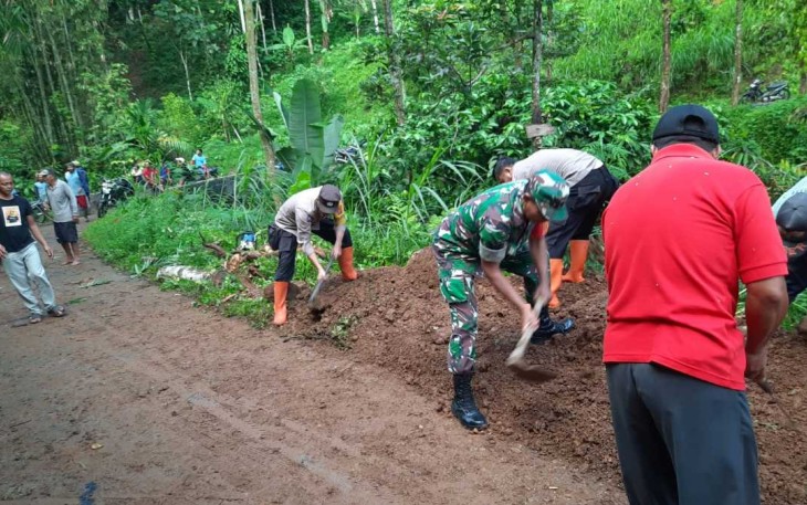 Bersihkan material longsor di jalan