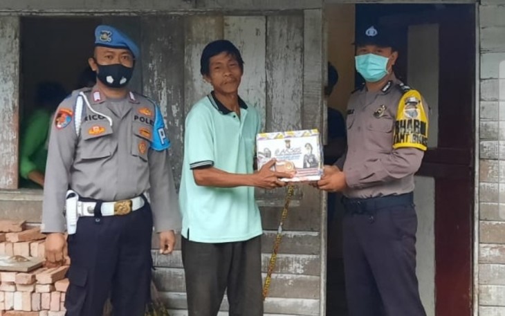 Bhabinkamtibmas saat berikan bingkisan ke masyarakat