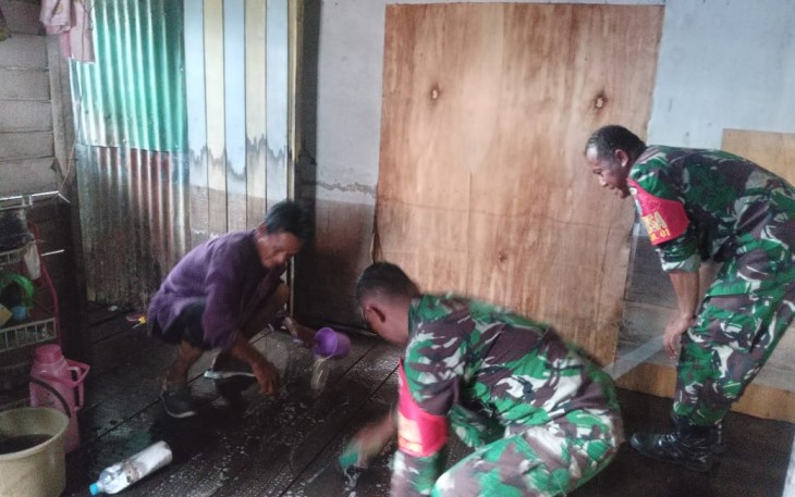 Babinsa Koramil Pahandut saat Bantu Warga Bersihkan Lumpur Bekas Banjir 