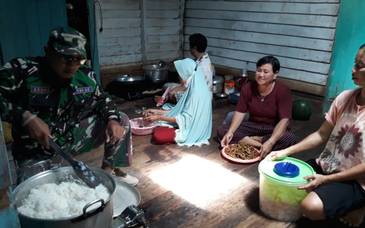 Anggota Satgas TMMD saat Bantu Masak Bersama Warga 