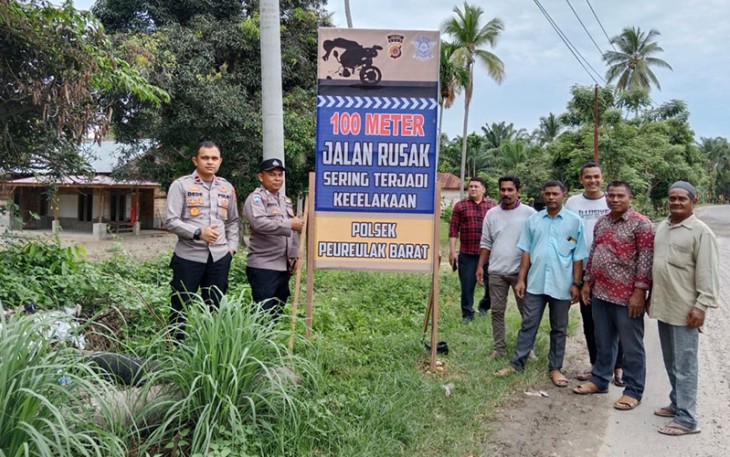 Aksi Tanggap Kapolsek Peureulak Barat saat Pasang Spanduk Himbauan Jalan Rusak
