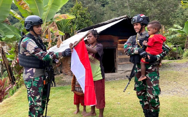 Masyarakat Yambi saat Kibarkan Bendera Merah Putih Bersama Satgas Yonif RK 115/ML