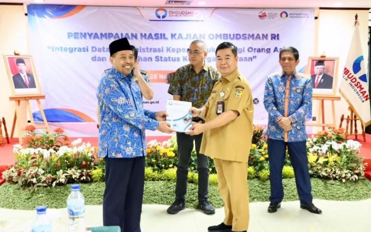 Ketua Ombudsman Muhammad Najih menyerahkan hasil kajiannya kepada Dirjen Dukcapil Teguh Setyabudi di kantor Ombudsman, Jakarta, Selasa (28/11/2023). (Foto: Dukcapil/Satrio) 