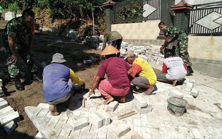 Gotong royong bersama warga pasang paving jalan desa