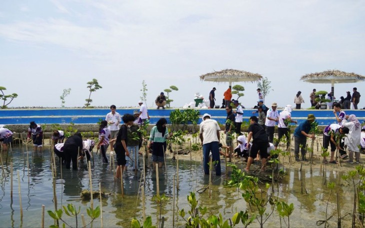 Mahasiswa UPER dan UTP saat melaksanakan penanaman mangrove dalam kegiatan Community Service Collaboration di pesisir Pulau Untung Jawa, Kepulauan Seribu, Selasa (02/05).
