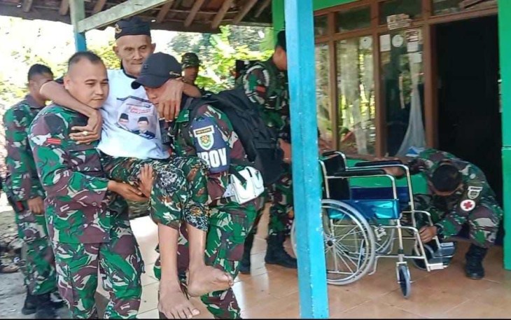 Veteran RI bapak Jaya dibopong saat menerima kursi roda dari Yonif Raider 301/PKS