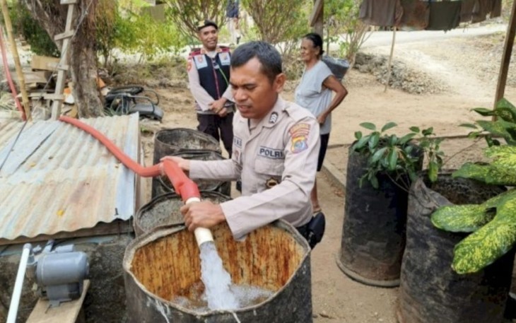 Anggota Polresta Kupang Kota saat mendistribusikan air bersih untuk masyarakat di Kelurahan Bello, Kota Kupang, Selasa (15/8)