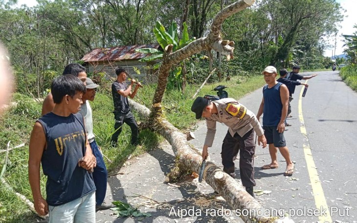 Bersama Warga Polsek Padang Ulak Tanding Bersihkan Ranting yang Menutupi Jalan 