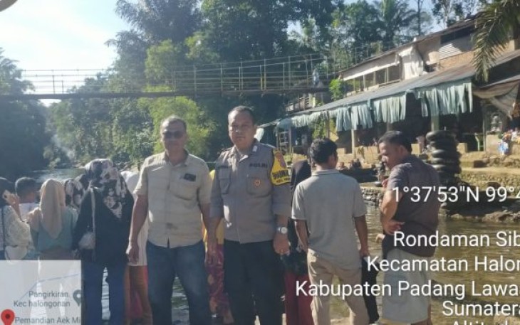 Bhabinkamtibmas Polsek Padang Bolak, Bripka Adam Pohan, hadir di tengah-tengah wisatawan yang sedang berkunjung ke Objek Wisata pemandian Aek Milas, Minggu (16/7/2023