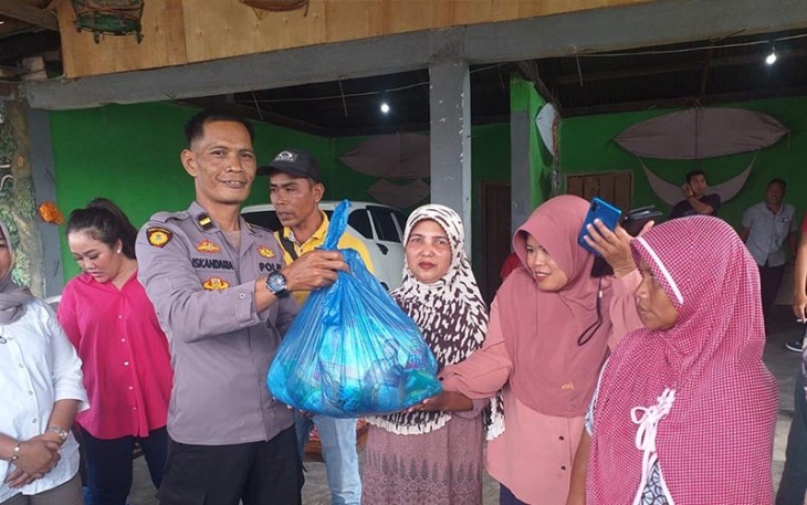 Bripka Hendri Putra Sekta saat menyalurkan bantuan langsung ke warga terdampak banjir.