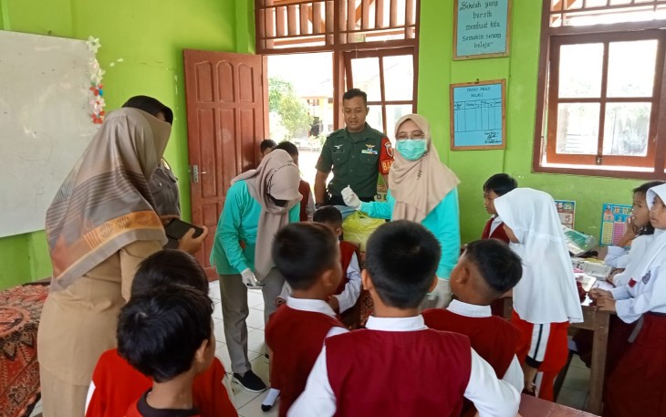 Babinsa Desa Singgit Kopda Andri Styawan anggota Koramil Tipe B 0807/11 Bandung bersama Bhabinkamtibmas mendampingi tenaga kesehatan dari Puskesmas melaksanakan kegiatan Sub Pekan Imunisasi Nasional (SubPIN) POLIO di SDN 1 Singgit Desa Singgit Kecamatan Bandung Kabupaten Tulungagung Jawa Timur, Senin (15/01/2024)