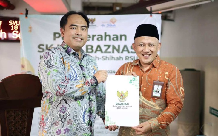 Ketua BAZNAS Depok, Endang Ahmad Yani (kanan) saat menyerahkan SK pembentukan UPZ RS UI