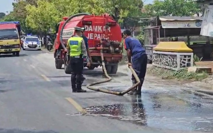 Polisi Jepara Gotong Royong Bersihkan Tumpahan Semen di Jalan