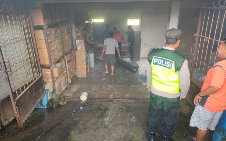 Petugas bersama warga saat mengevakuasi barang-barang dari dalam toko pupuk di Dusun Gedangan, Desa Salam, Kecamatan Karangpandan, yang terbakar Sabtu (13/4/2024) pagi.