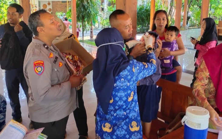Babinsa Koramil 15/Kartoharjo saat Dampingi Imunisasi Polio Bagi Anak