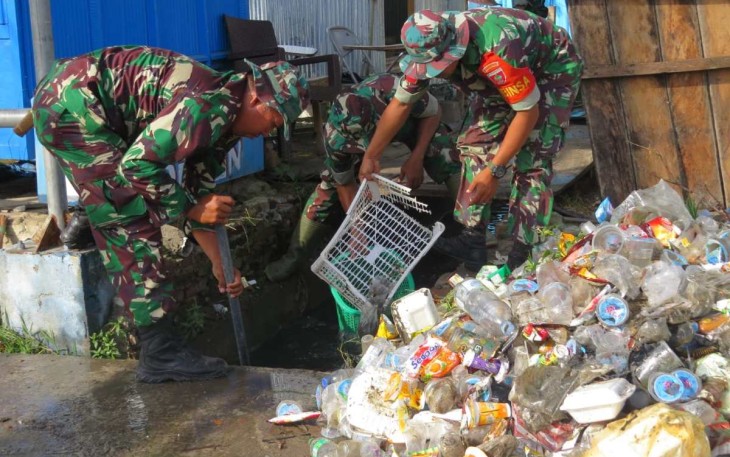 Prajurit Kodim 1401/Majene saat membersihkan sampah di pasar Ole-ole Kelurahan Lembang, Jum'at (1/3)