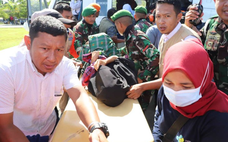 Tim gabungan menurunkan warga yang sakit dari Helikopter Bell BNPB menuju Pos Kesehatan di Pos Komando Utama Tanggap Darurat Banjir dan Tanah Longsor Kabupaten Luwu Sulawesi Selatan, Rabu (8/5).