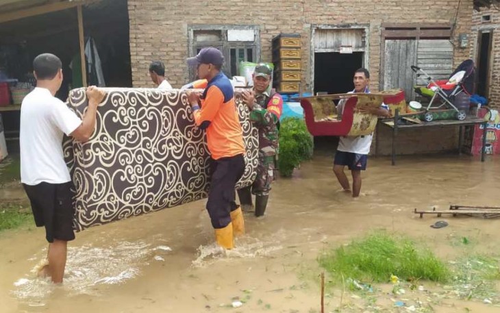 Tim BPBD Kab. Pringsewu membantu warga mengevakuasi diri dan harta benda menyusul banjir yang merendam akibat meluapnya Sungai Way Tebu, Jumat (24/5) malam