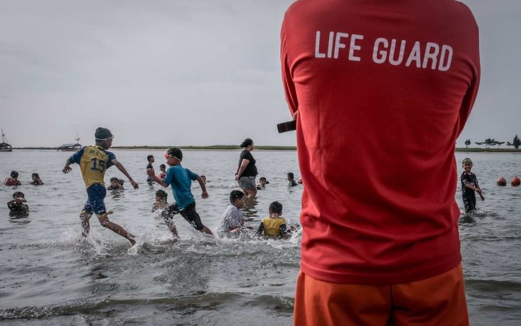 Wisatawan menikmati deru ombak di pantai 