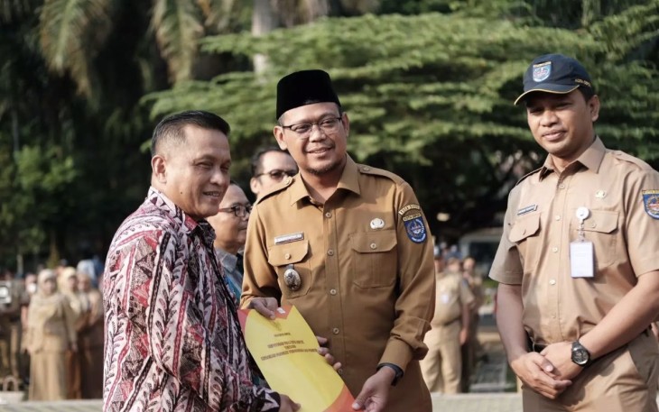 Wakil Wali Kota Depok Imam Budi Hartono (tengah) menyerahkan SK pensiun kepada Hasan Nurdin (kiri) yang menjabat sebagai Camat Cipayung, pada apel pagi, di Halaman Balai Kota Depok, Senin (02/09/24).