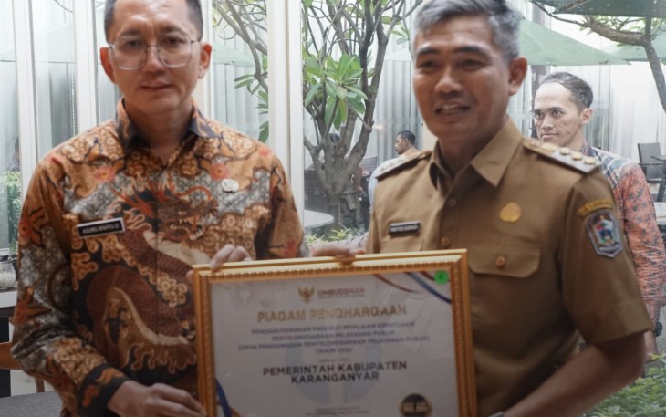 Pj Bupati Karanganyar Timotius Suryadi memegang piagam penghargaan predikat tertinggi kepatuhan penyelenggaraan pelayanan publik tahun 2024 dari Ombudsman Republik Indonesia