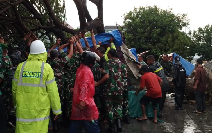 Prajurit TNI dari Kodim 0727Karanganyar mengevakuasi korban tertimpa pohon tumbang, di kawasan plaza alun-alun Karanganyar, Jumat (2132025) sore.