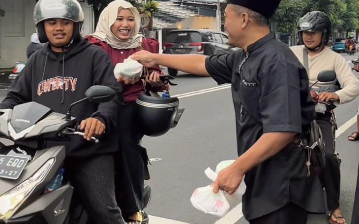 Ketua Koordinator Wilayah Malang Raya, Aries Pratomo, saat tengah membagikan takjil gratis kepada pengendara yang melintas, Minggu (15/3)
