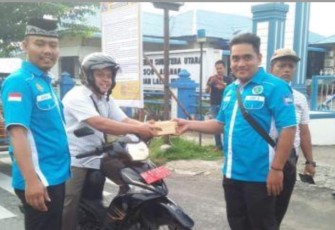 Personil Satnarkoba Polres Asahan saat membagikan takjil kepada pengendara roda 2 di Kota Kisaran. Rabu, (15/5/2019).