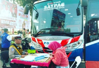 Petugas Kepolisian Satlantas Polres Blitar Kota Saat Melayani Masyarakat Mengurus SIM di Layanan Mobil SIM Keliling